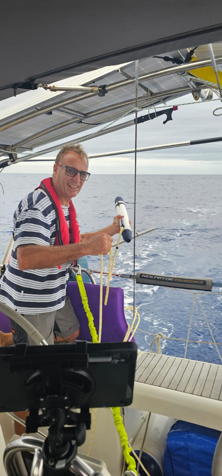 A Pacific Rally sailor holding ocean-sampling equipment aboard Eudora